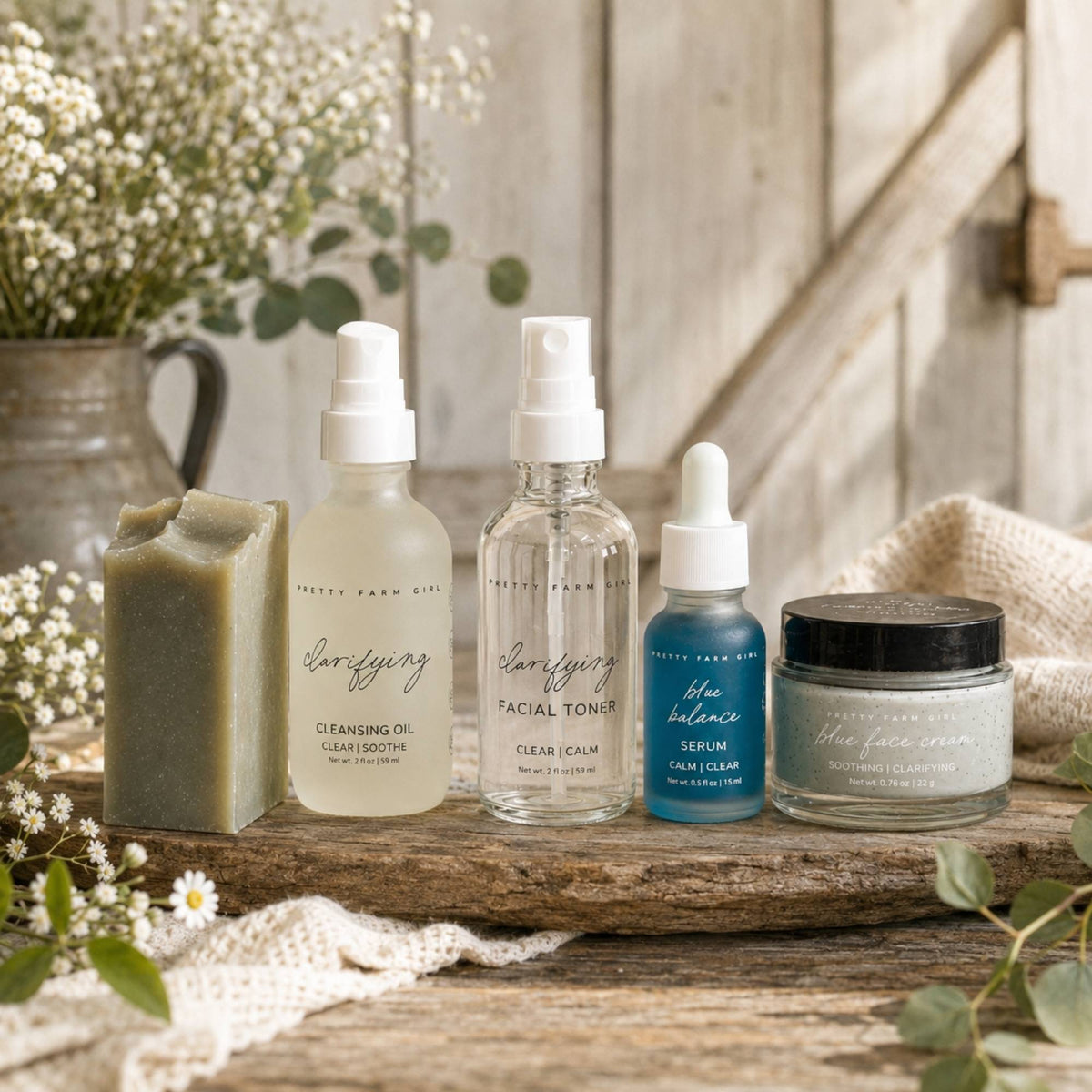 Skincare routine kit with cleansing oil, facial toner, blue serum, and cream jar