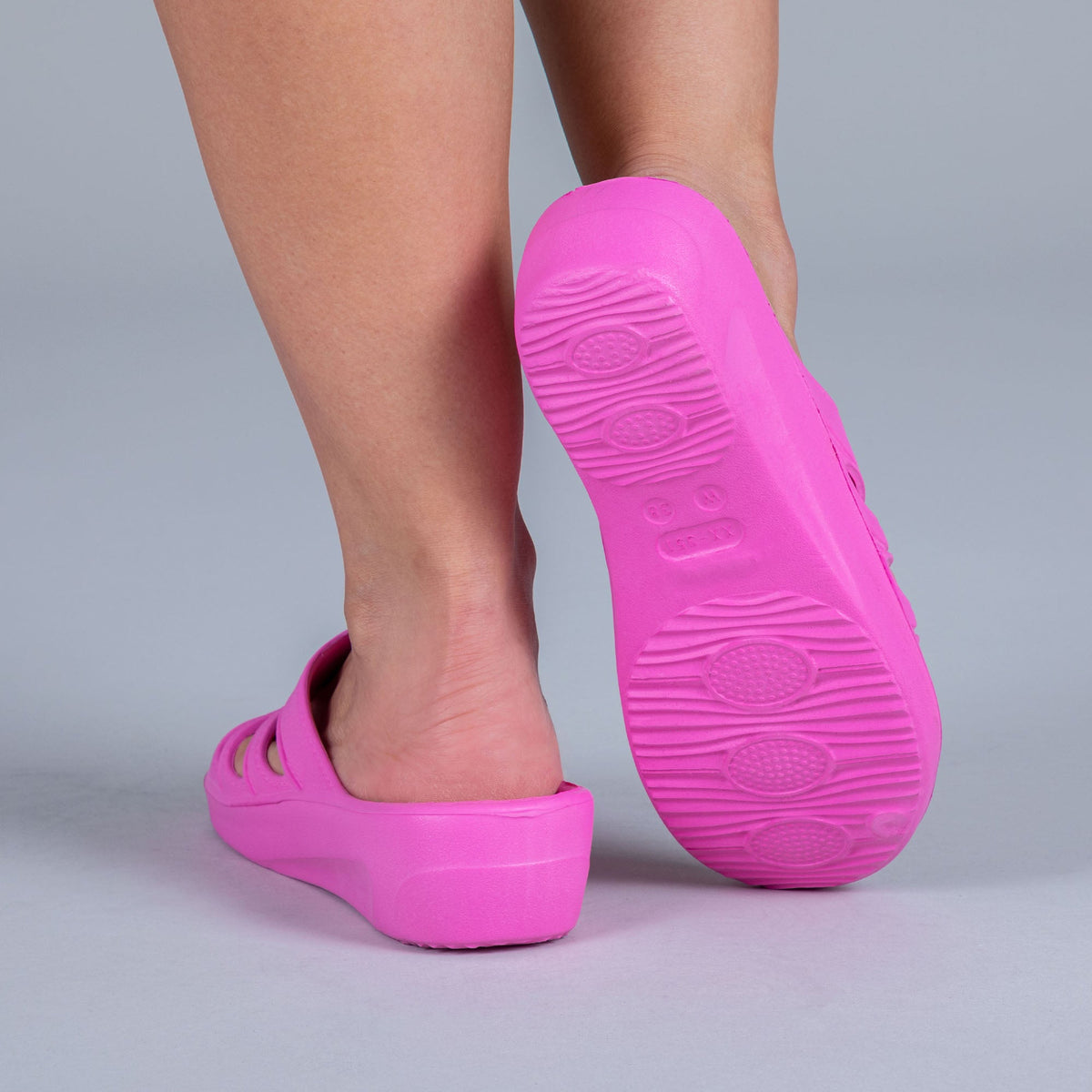 Pink slide sandals with textured rubber sole tread
