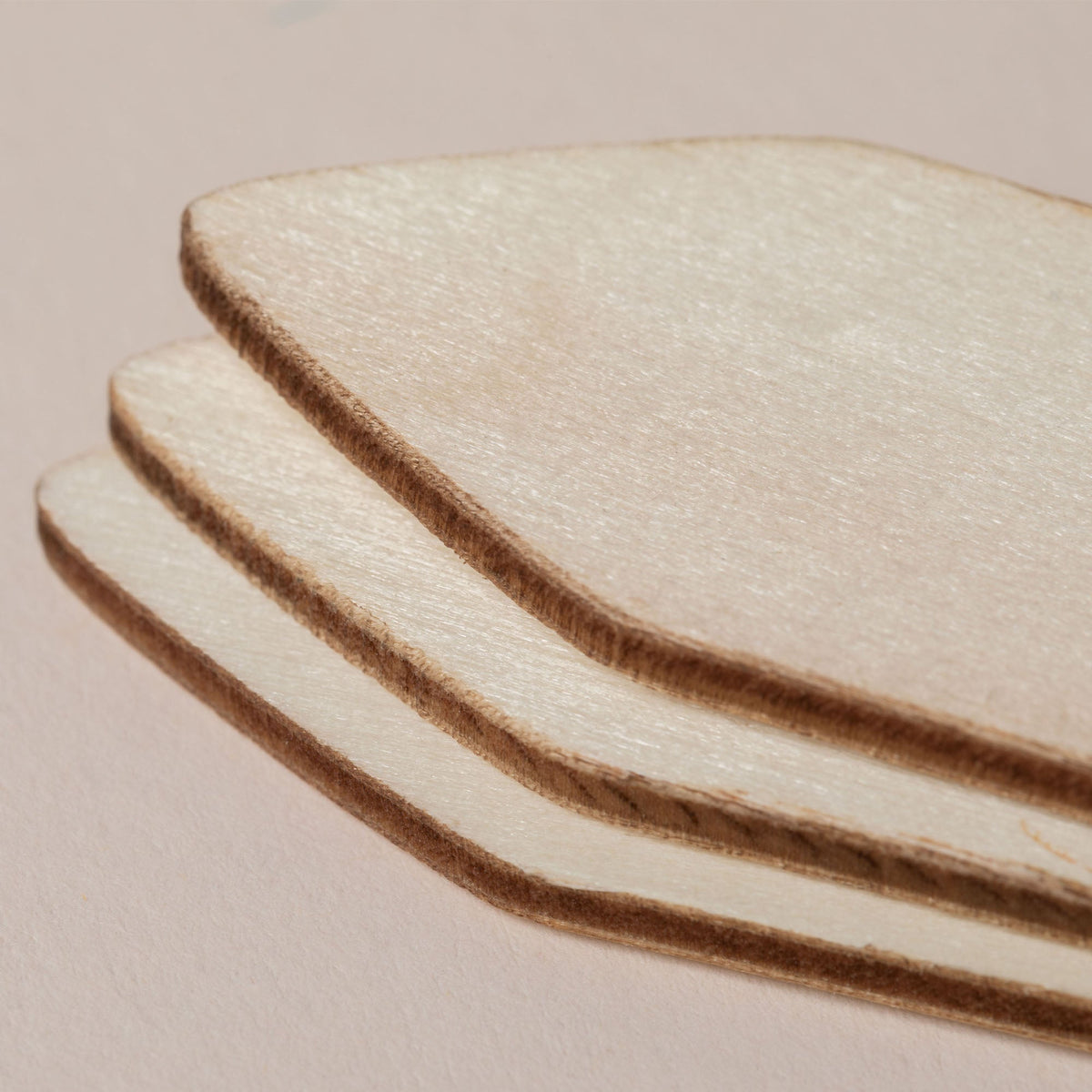 Three curved wooden plant markers