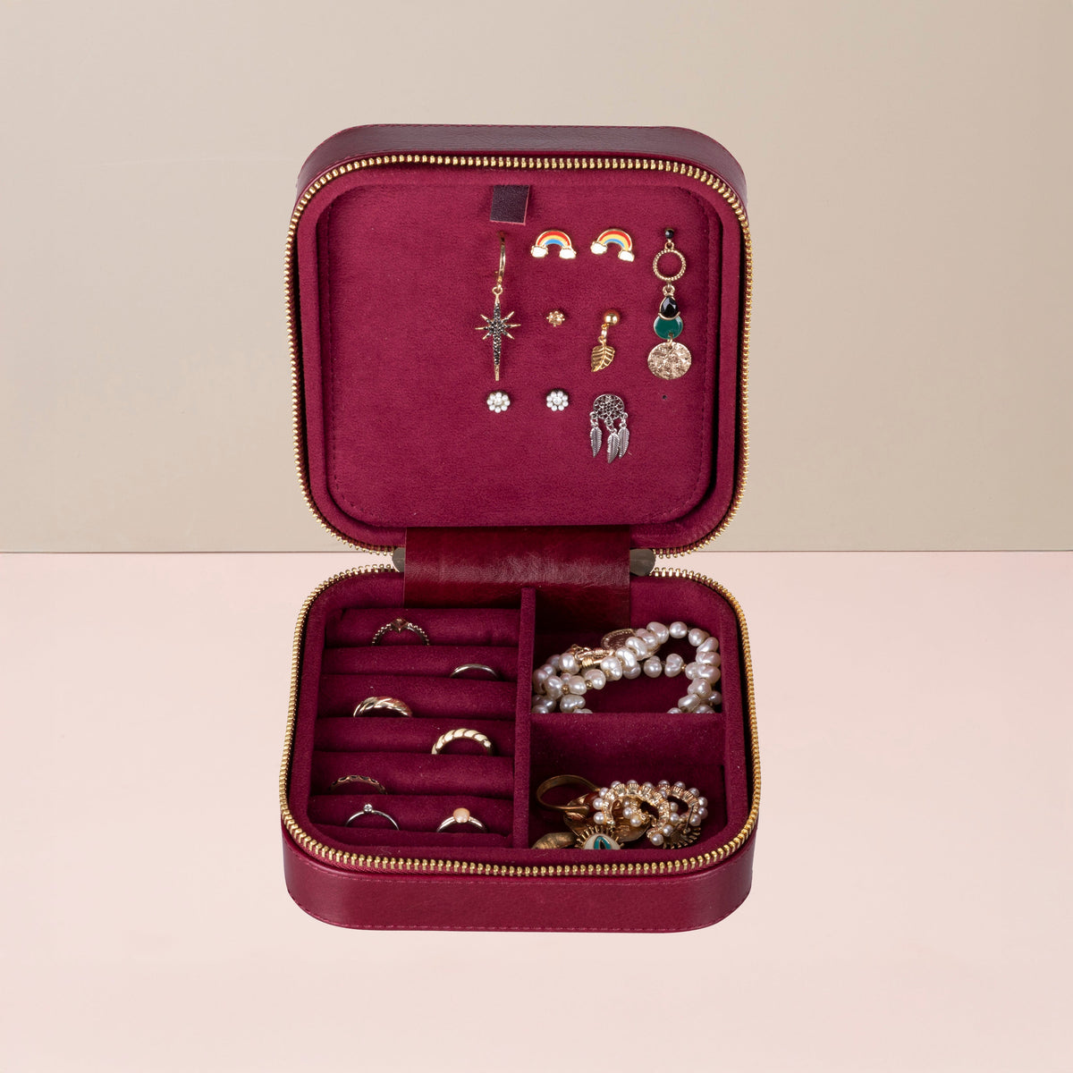 Red velvet travel jewelry box open, display panels with hooks and ring sections