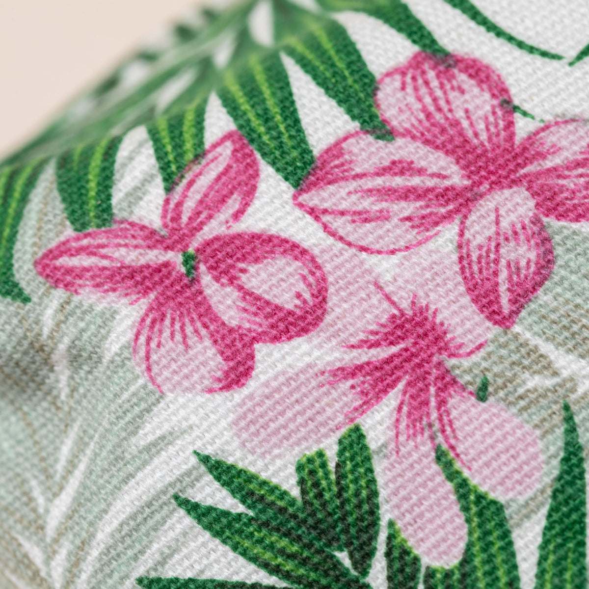 Tropical floral fabric with pink hibiscus blooms and green palm leaves