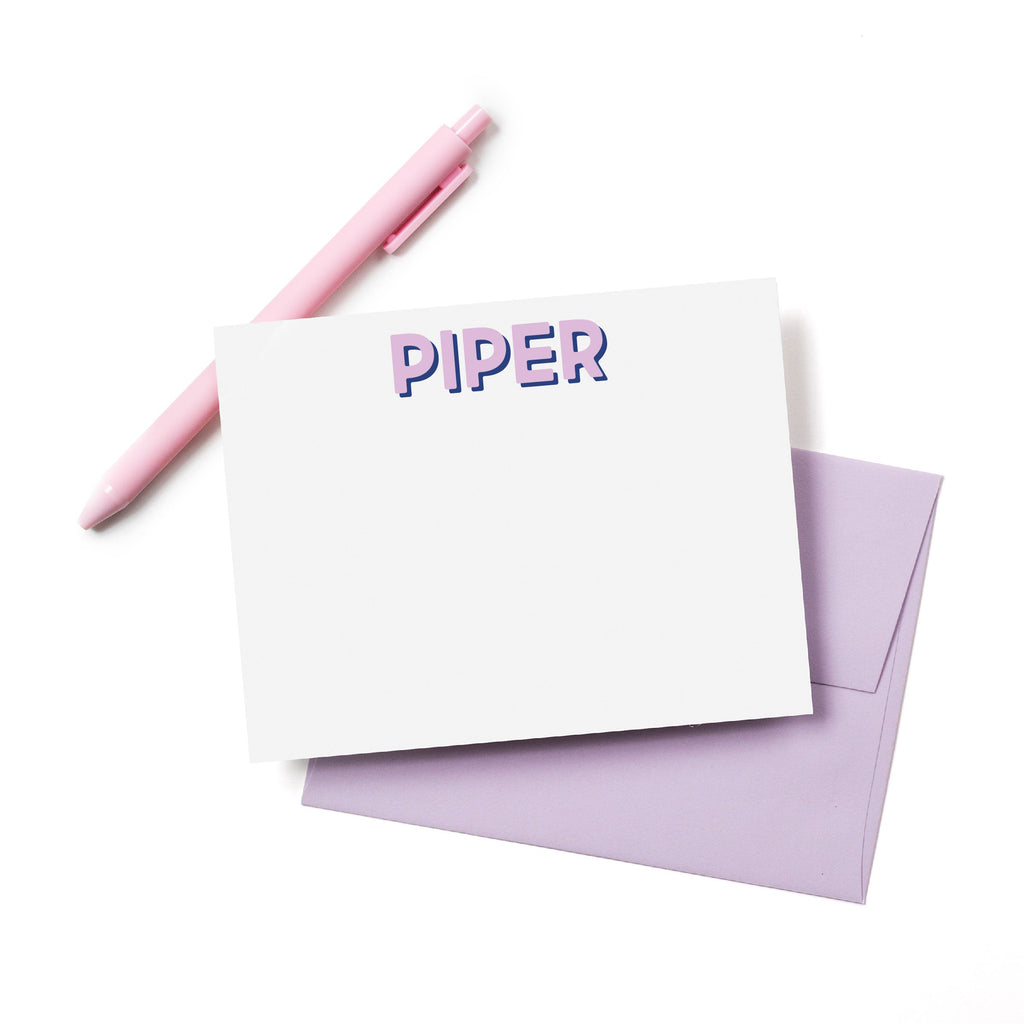 Personalized name card with purple “PIPER” text; white card, purple envelope, pink pen