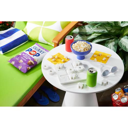 Skinny Pop kettle corn bag on a table beside a snack serving plate