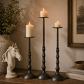 Hammered metal pillar candle holder with textured base, holding white pillar candle