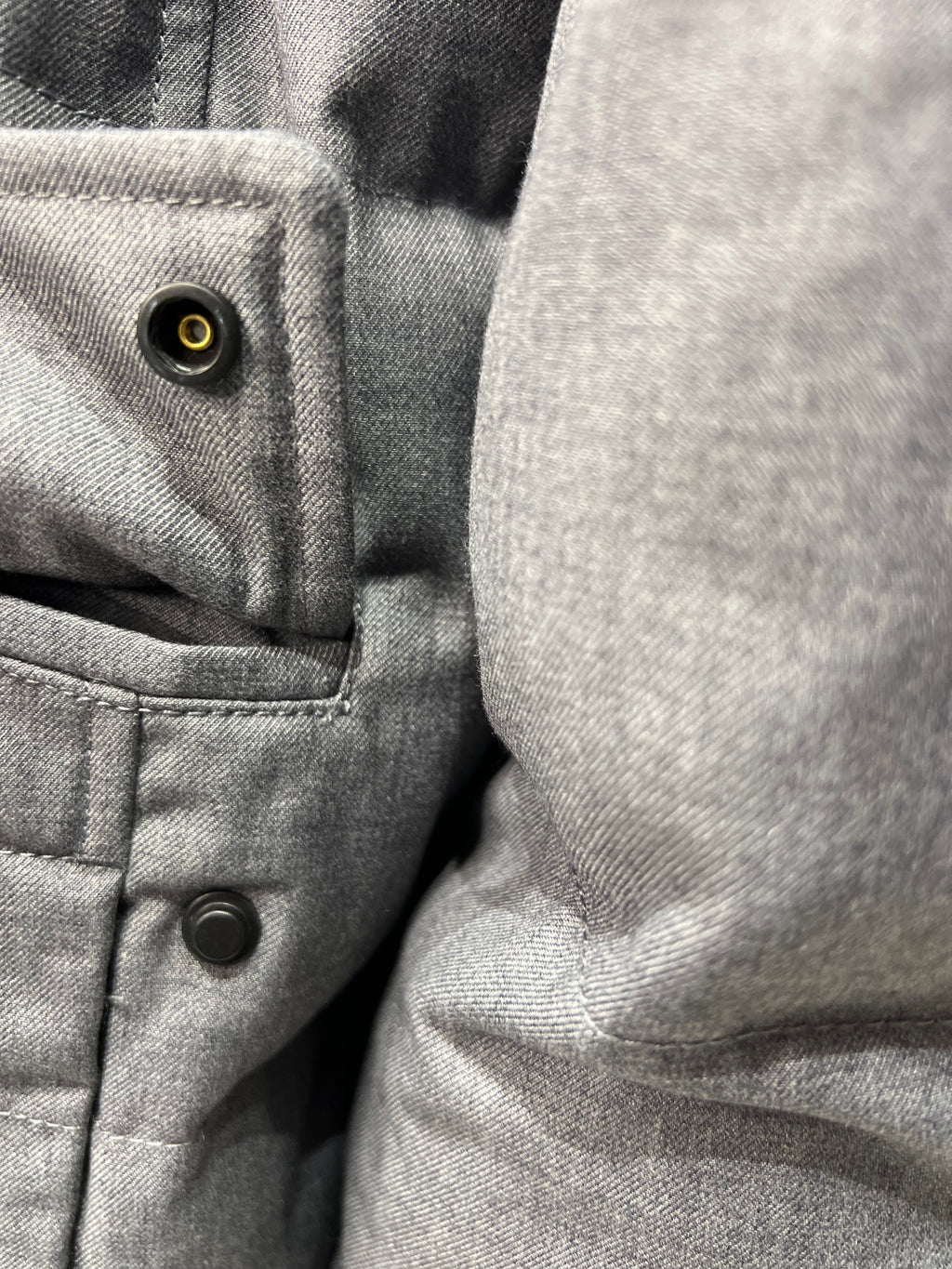 Grey coat close-up of snap placket and inner pocket opening