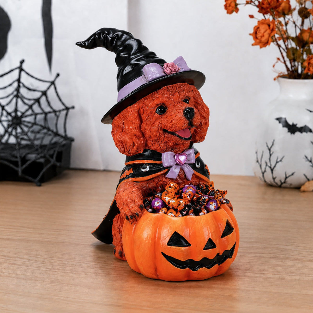 Brown dog witch decoration with a purple bow and jack-o'-lantern candy bowl