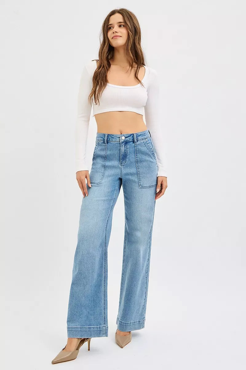Medium wash high-rise straight-leg jeans worn with heels, front pockets