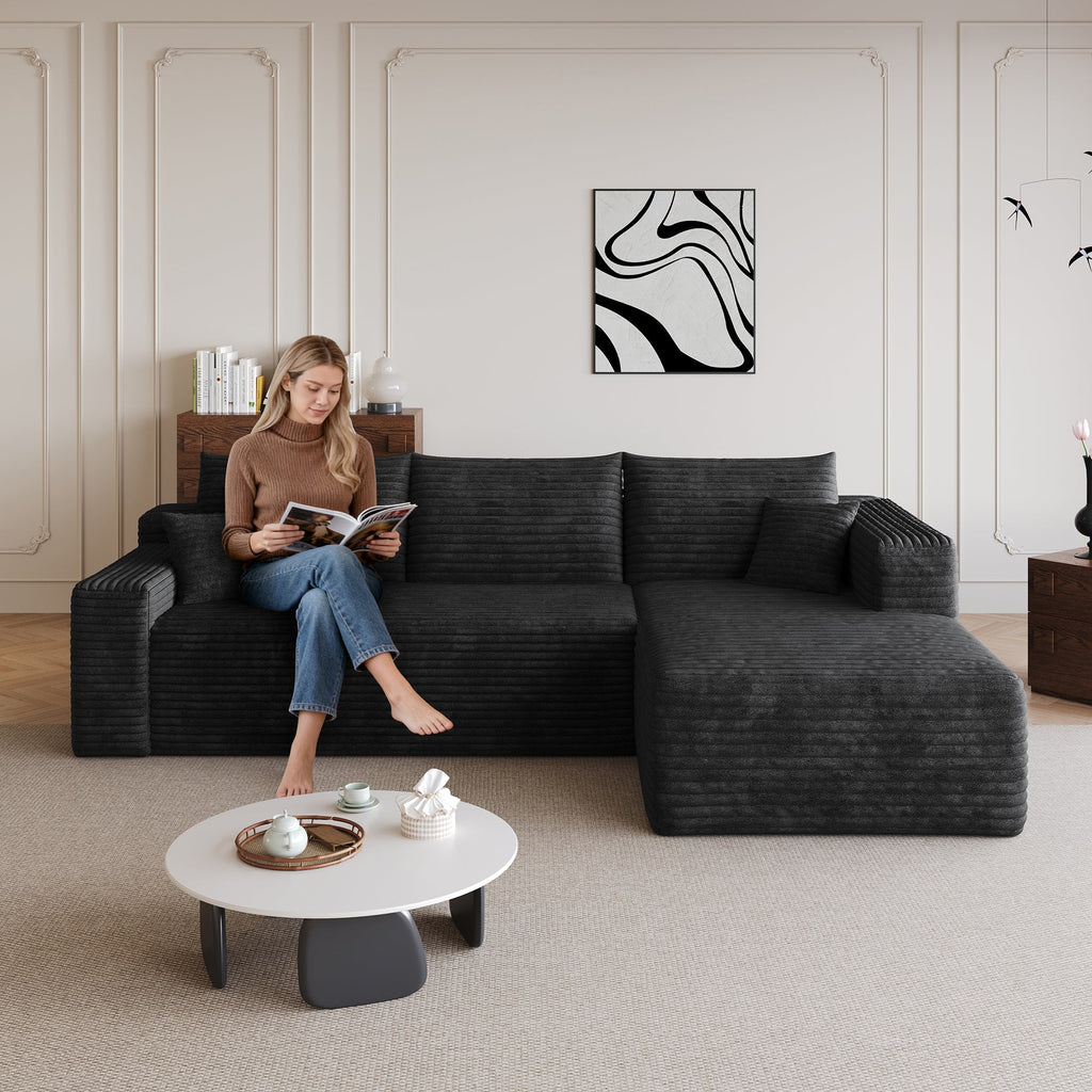Black sectional sofa with L-shaped chaise and three back cushions