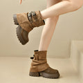 Tan slouchy platform combat ankle boots with buckled straps and chunky tread sole.