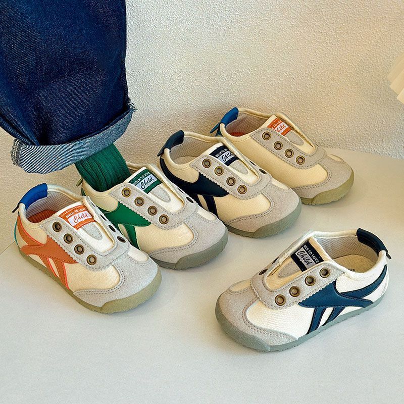 Kids casual sneakers with white uppers, blue heel trim, orange and green side accents.