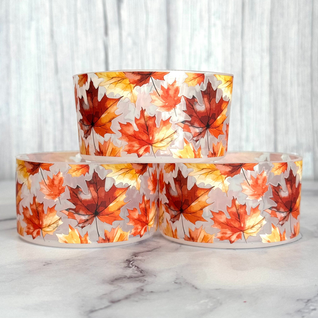 Transparent bottle boot sleeve with orange and red fall leaf print, two rolls