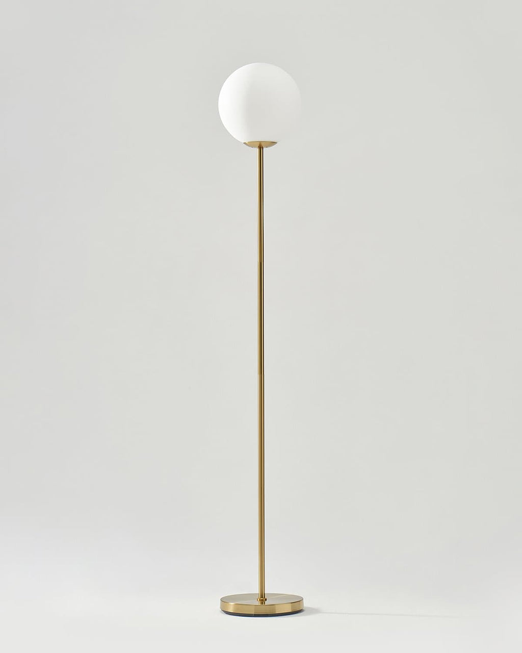 LED floor lamp with tall antique brass stand and frosted white globe shade, round base