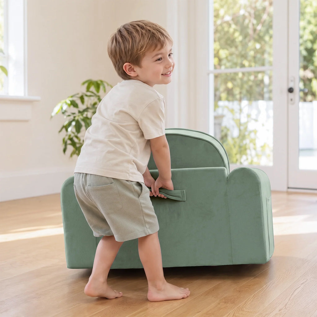 Light green kids sofa chair with low back and front handle pocket, child standing