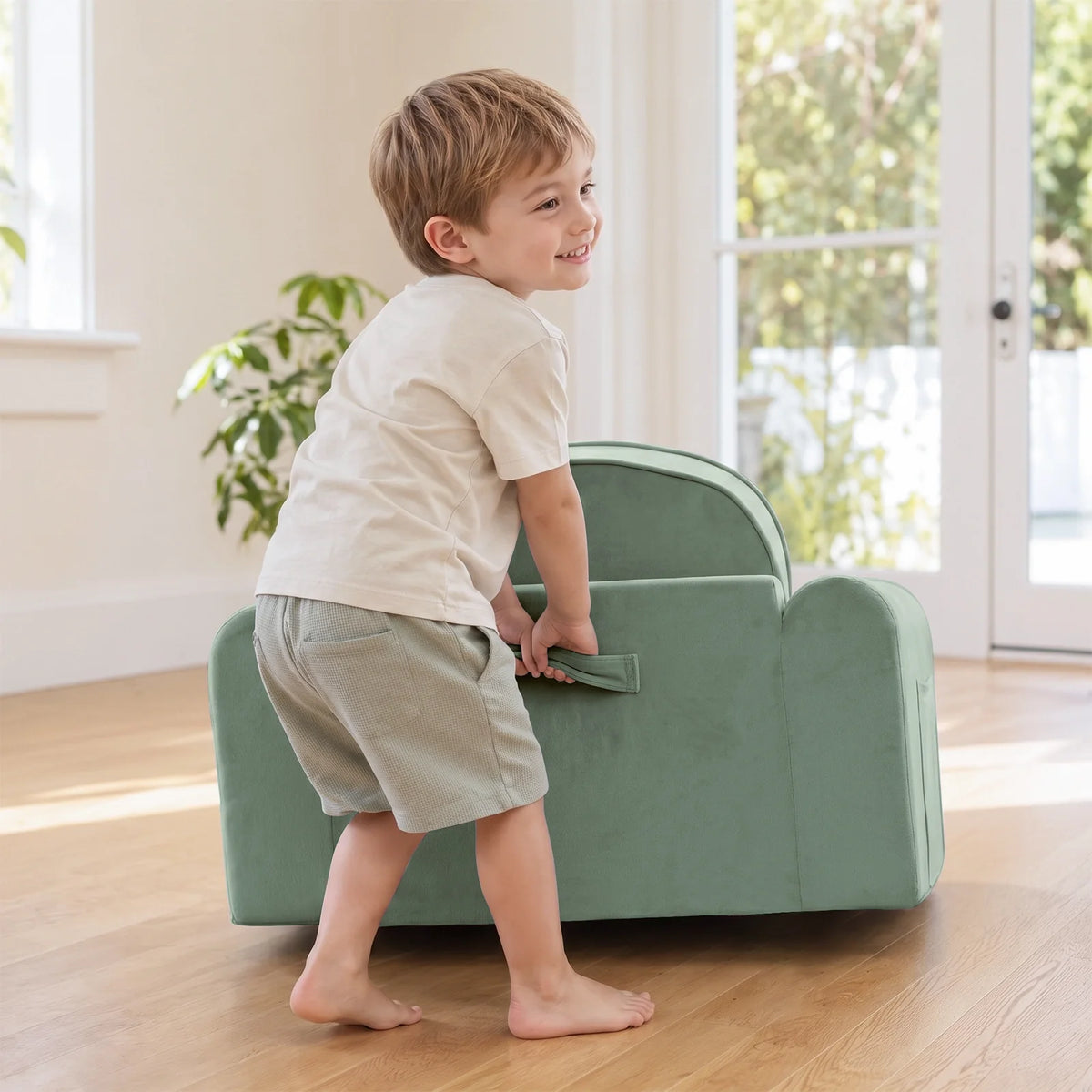 Light green kids sofa chair with low back and front handle pocket, child standing
