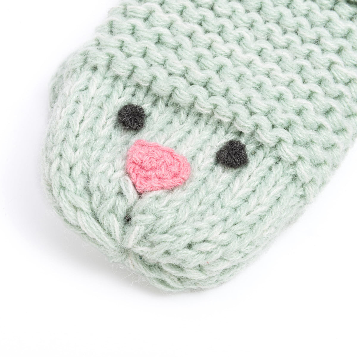 Mint green knitted chick mitten close-up with embroidered face and stitched beak
