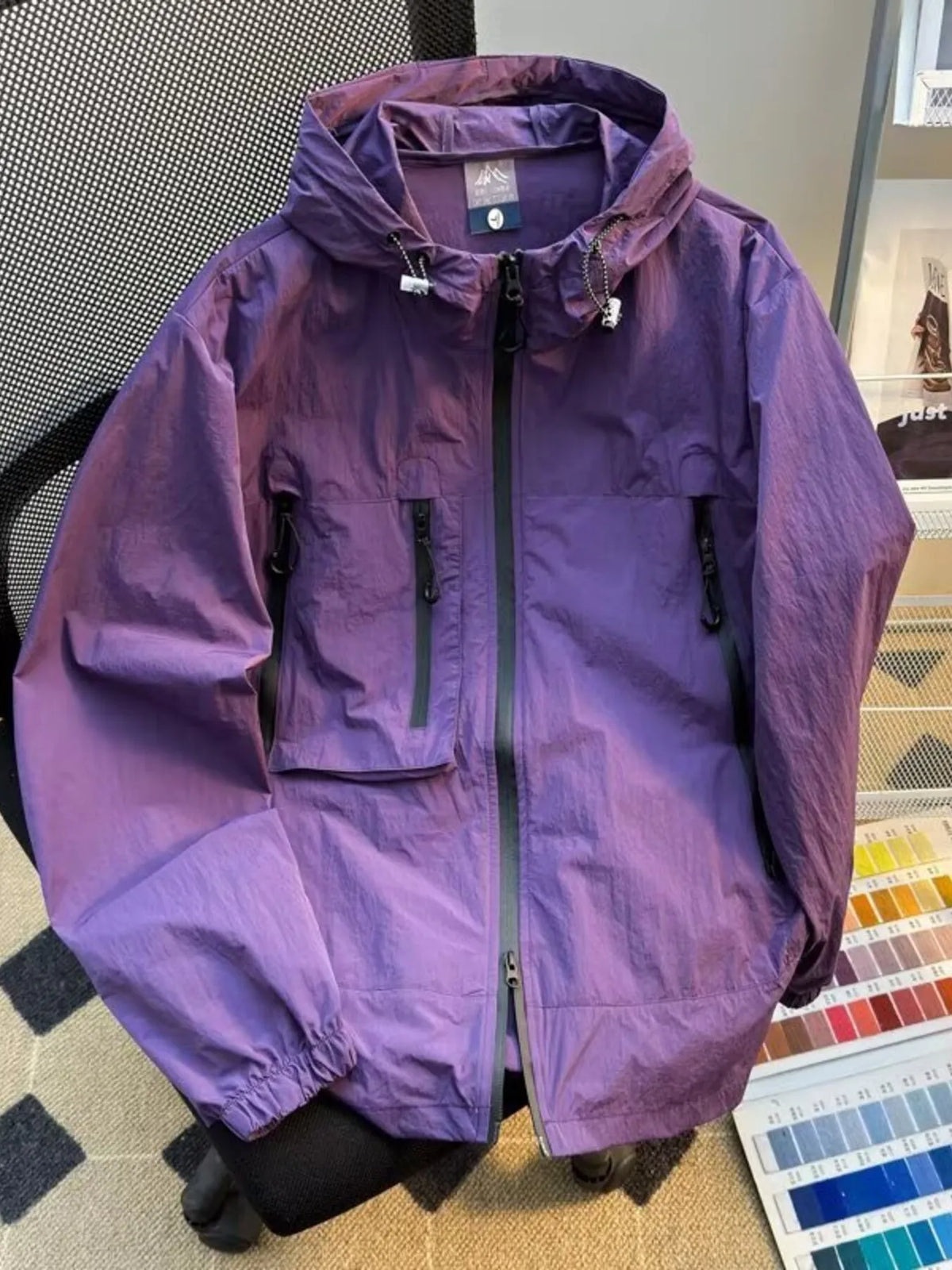 Lightweight hooded windbreaker jacket in purple with full zip and flap chest pockets