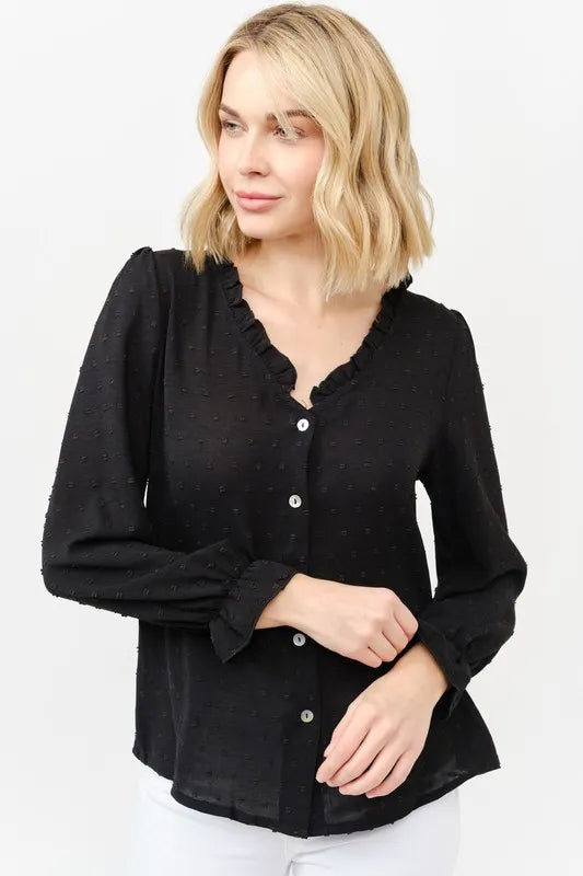 Black polka-dot blouse close-up: ruffle neckline and button front