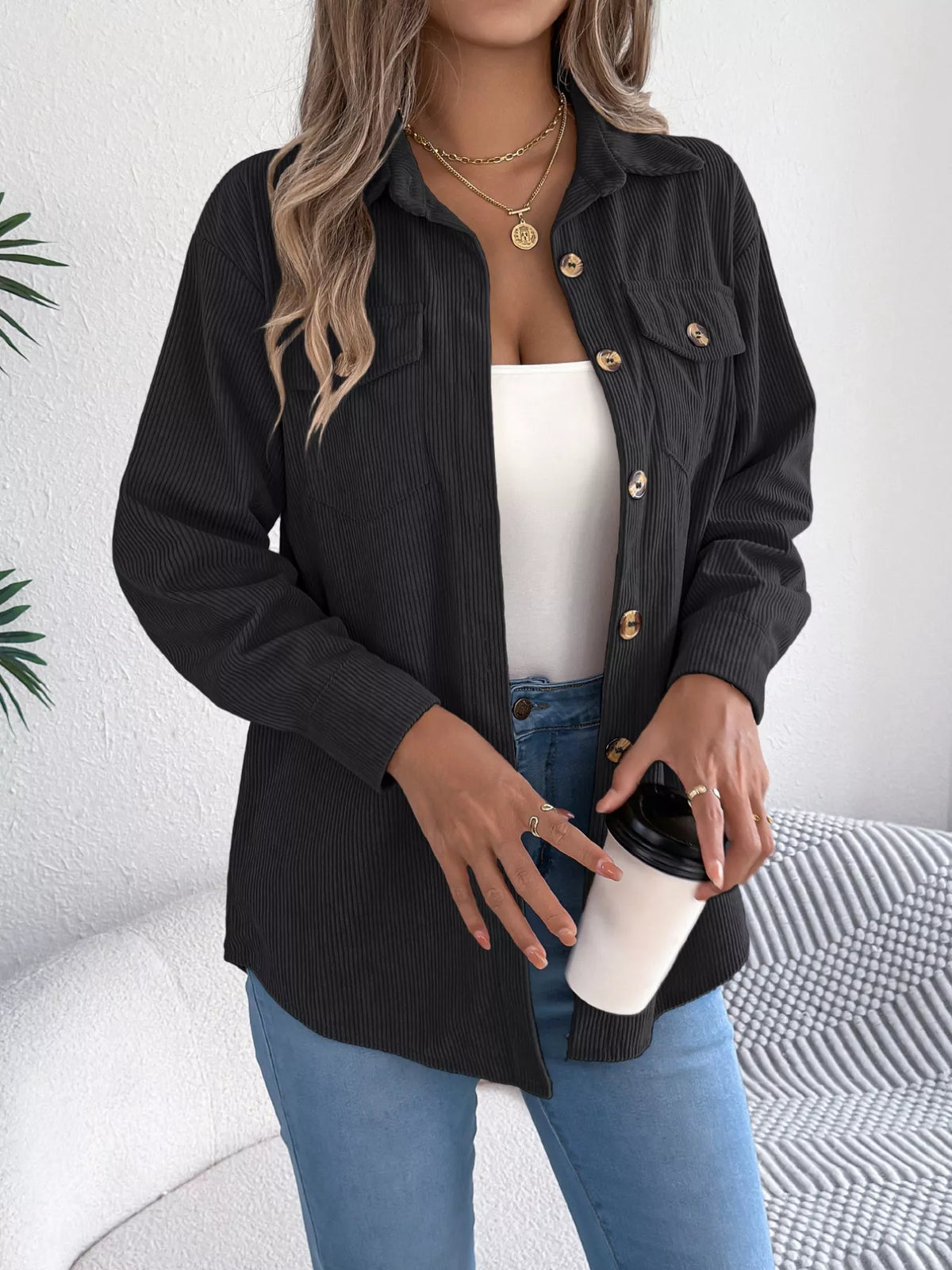 Black corduroy button-up shacket with point collar and buttoned chest flap pockets.