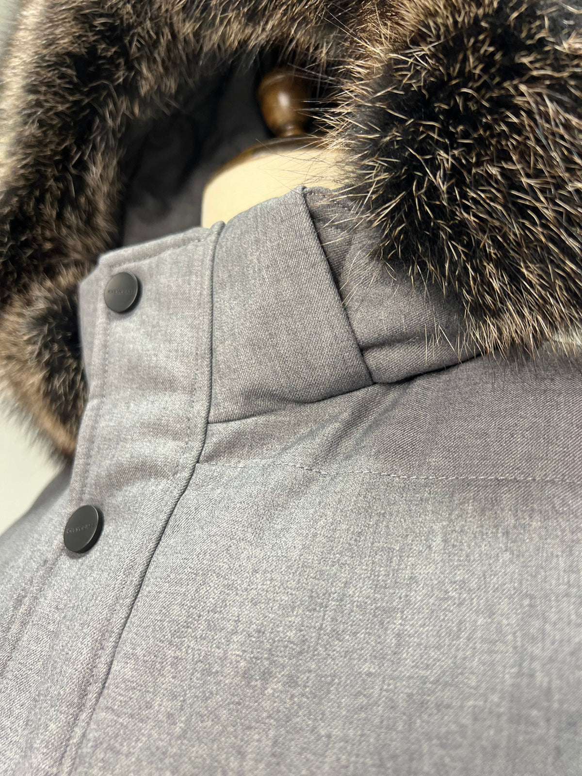 Grey coat close-up of hood fur trim and two-button front placket