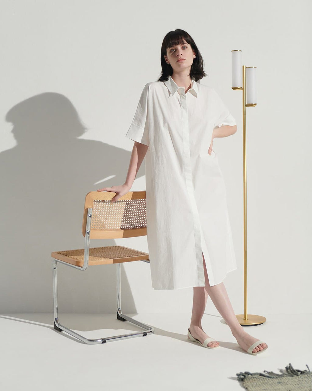 Brass floor lamp with two frosted glass cylinders on a long slim stand
