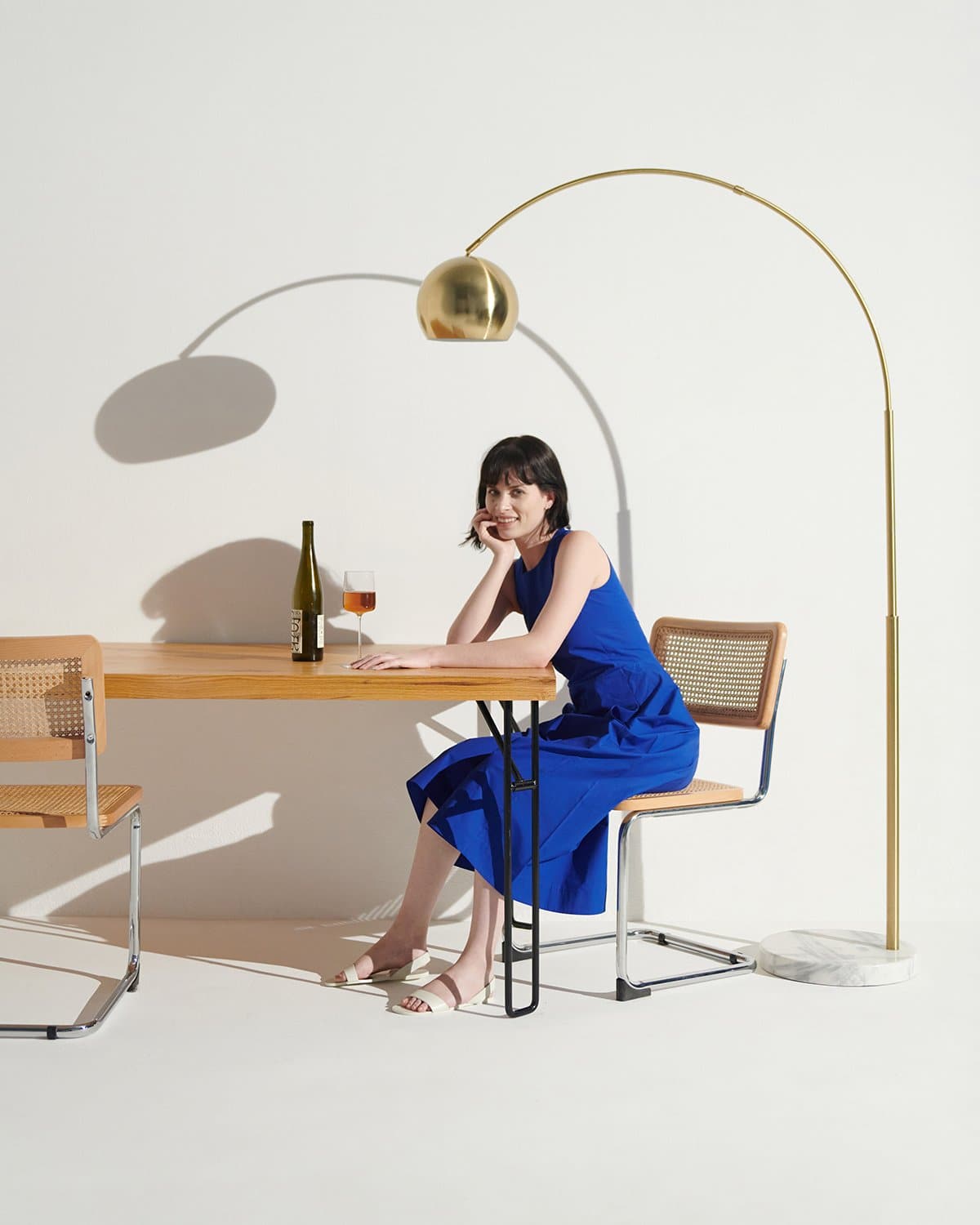 Gold-tone arc floor lamp with rounded dome shade and curved arch