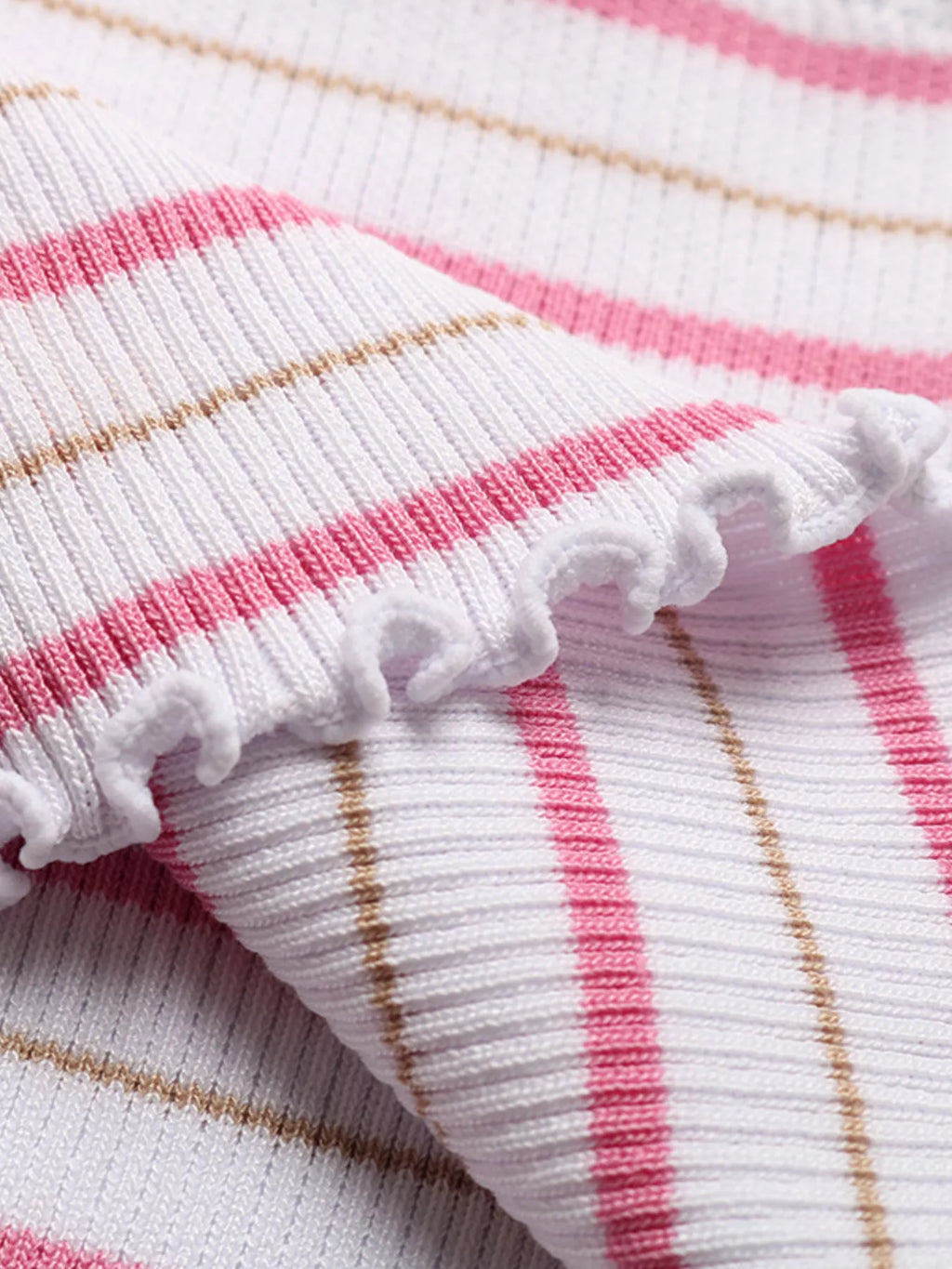 Close-up knit fabric of pink, white, and tan stripes with white ruffle edge