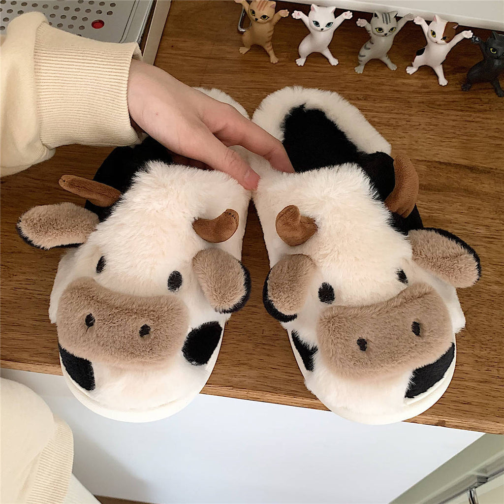 Plush cow slide slippers with cartoon faces, black patches, and brown ear accents, cozy lining