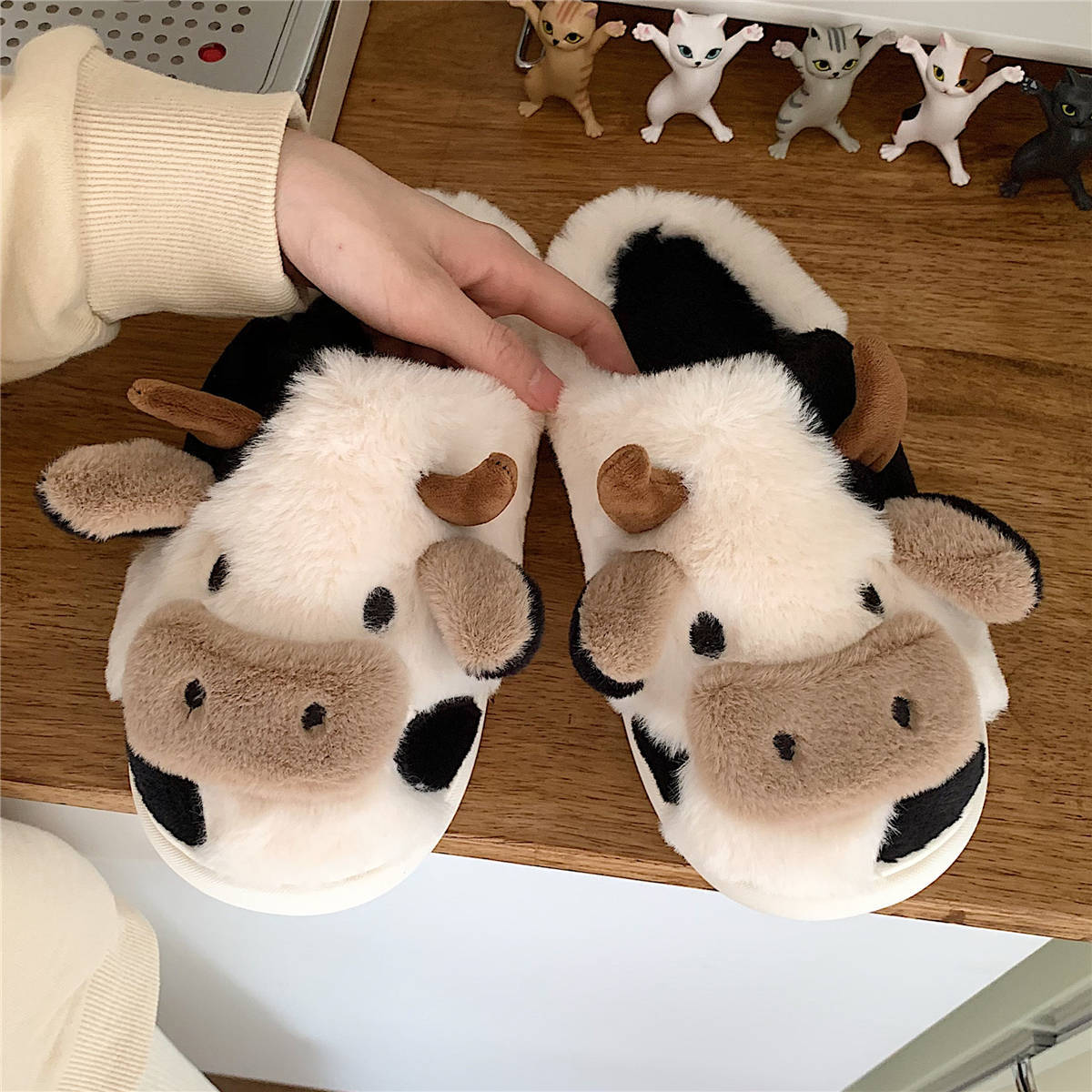 Plush cow slide slippers with cartoon faces, black patches, and brown ear accents, cozy lining