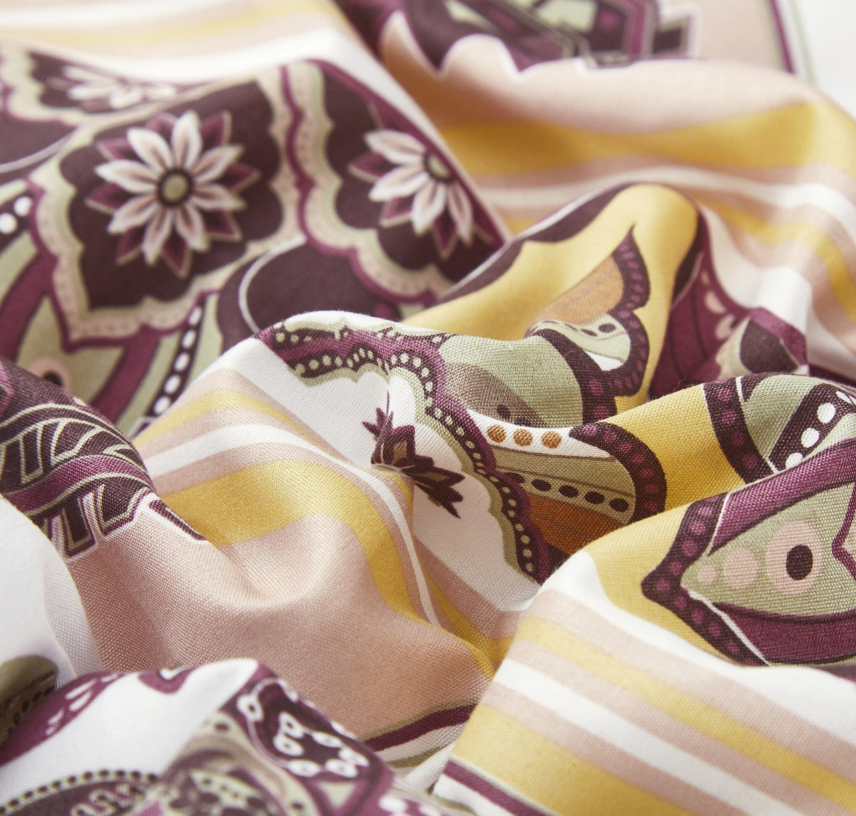 Close-up fabric detail of fitted sheet and pillowcases with kilim-inspired pattern in cream