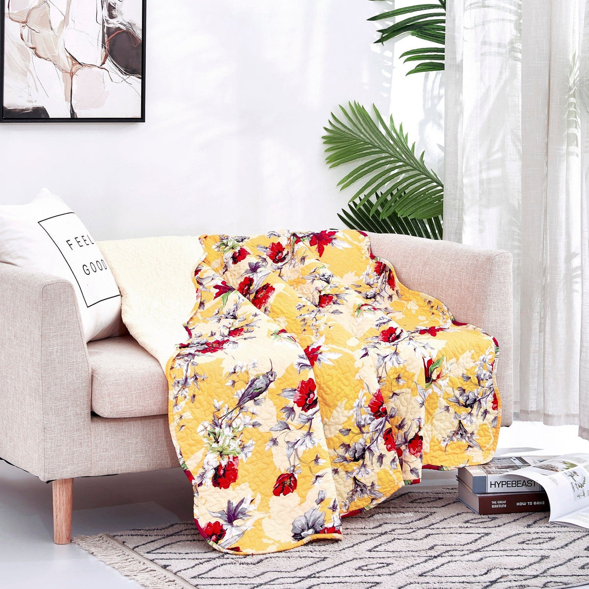 Yellow floral quilted throw blanket with scalloped edges on sofa