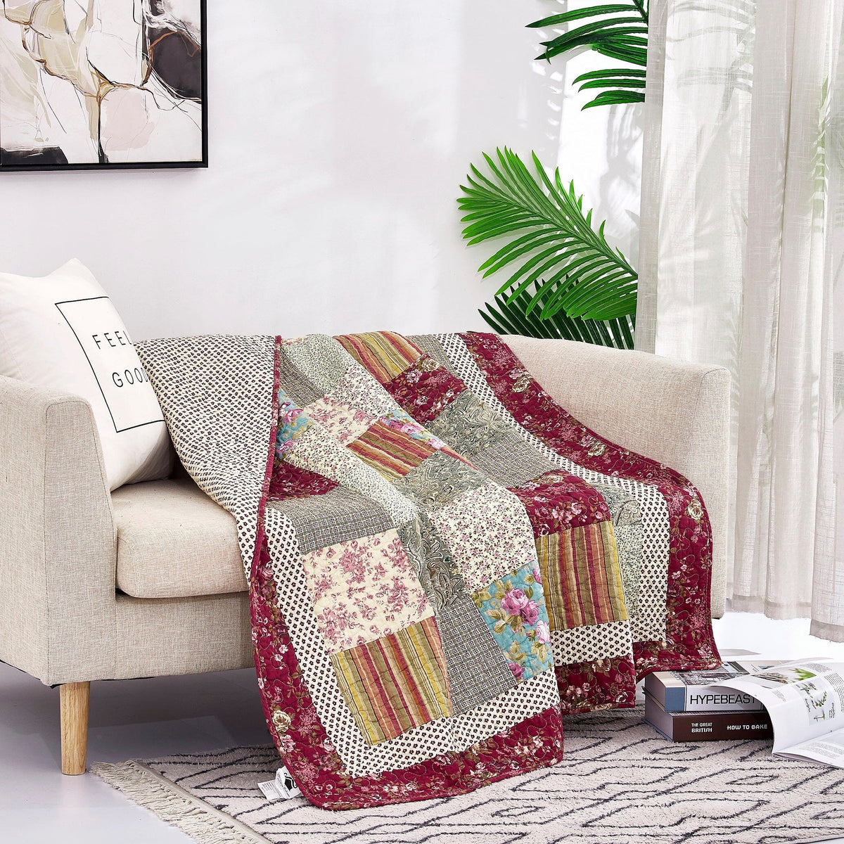 Folded patchwork quilted throw blanket with beige, burgundy, and multicolor floral panels.