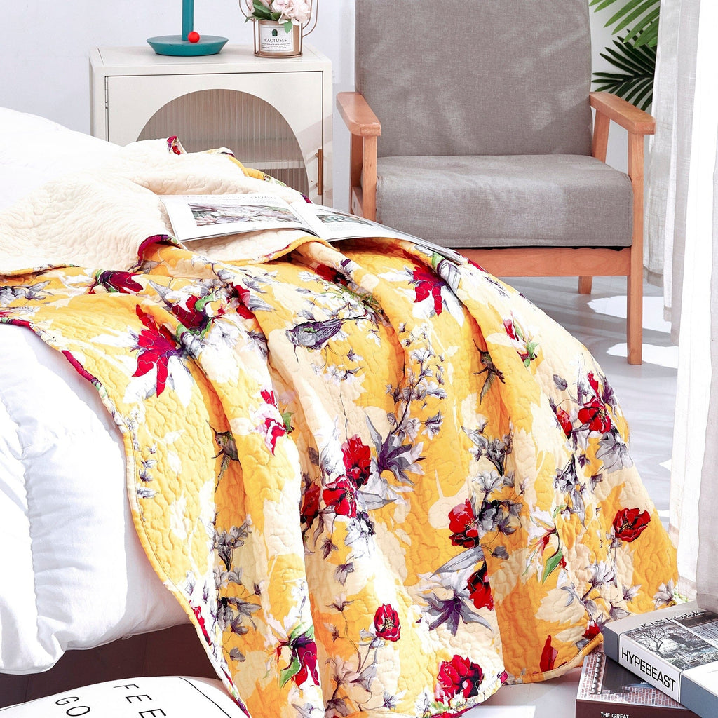 Yellow floral quilted throw blanket draped over bed