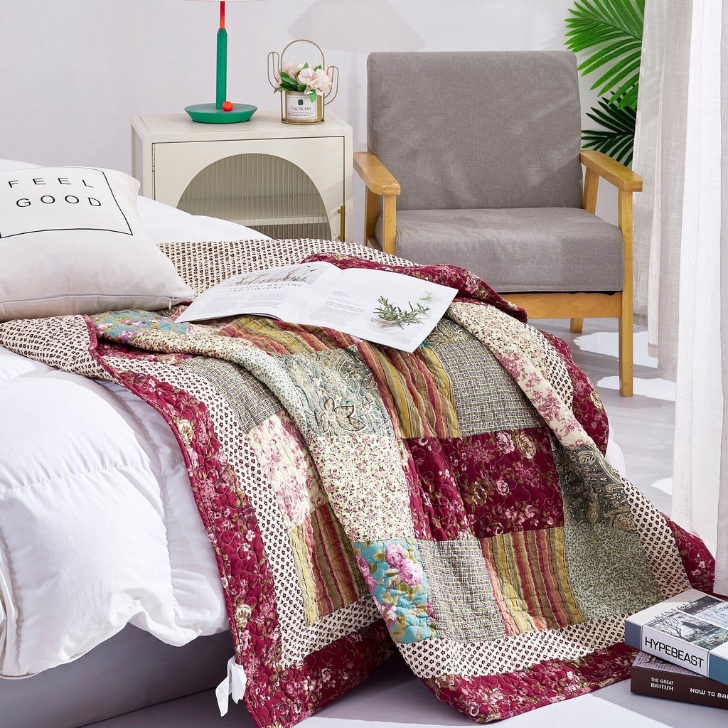 Quilted patchwork throw blanket with burgundy floral and beige striped fabric squares.