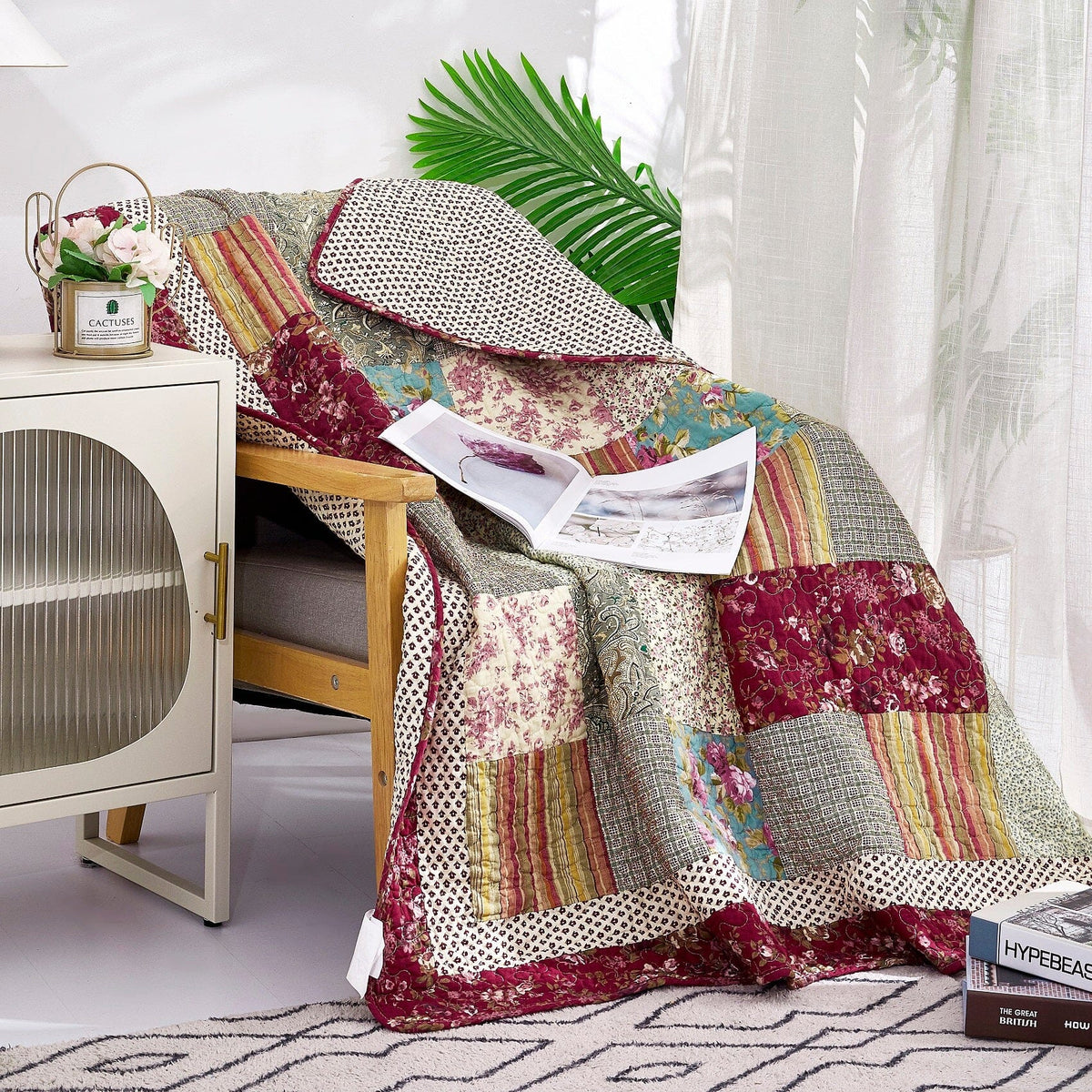 Patchwork quilted throw blanket in beige, burgundy, and teal with floral and stripe blocks.