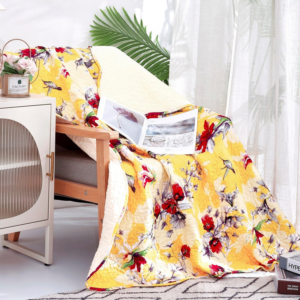 Yellow floral quilted throw blanket with scalloped edges on chair