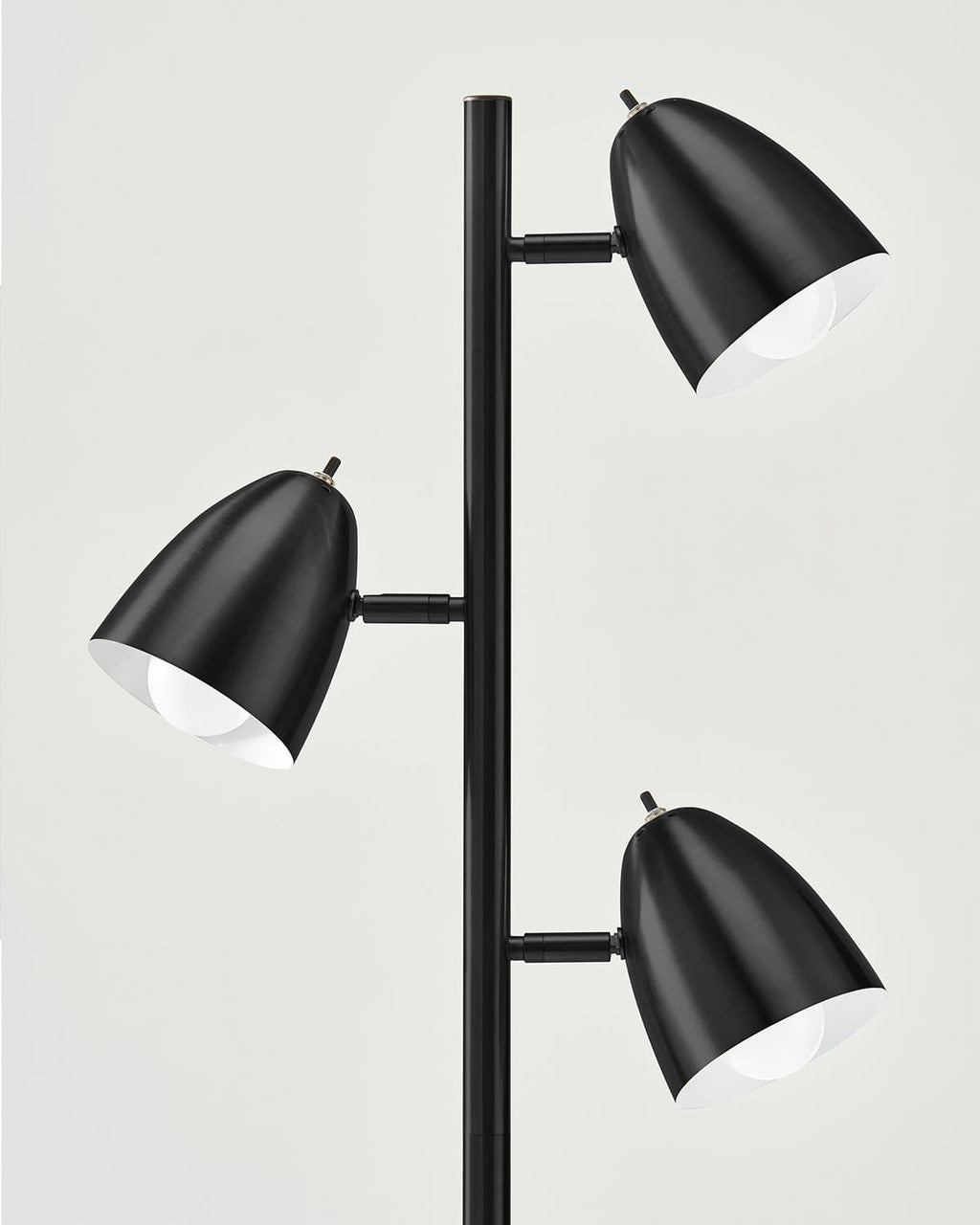 Black floor lamp with four cone shades, white inner lining, and pole stand