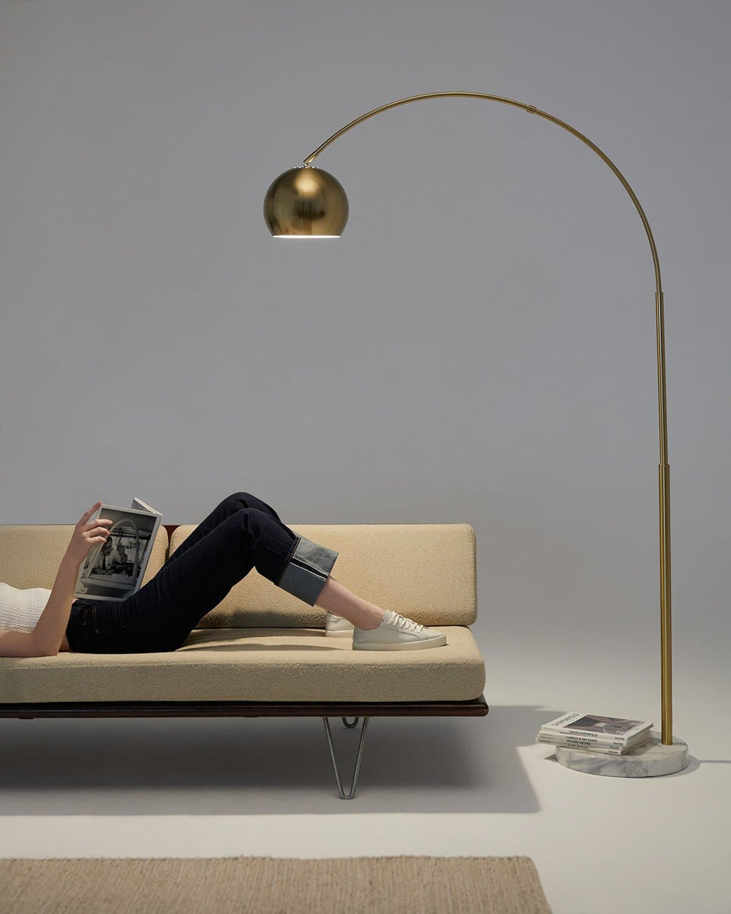 Brass arc floor lamp with small dome shade and round marble-look base