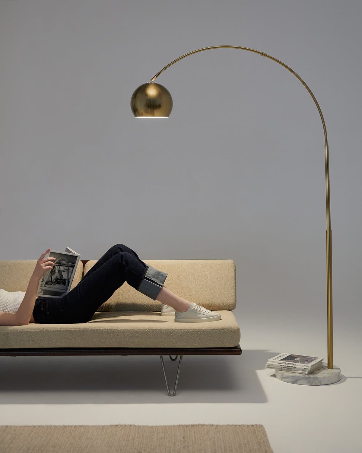 Brass arc floor lamp with small dome shade and round marble-look base