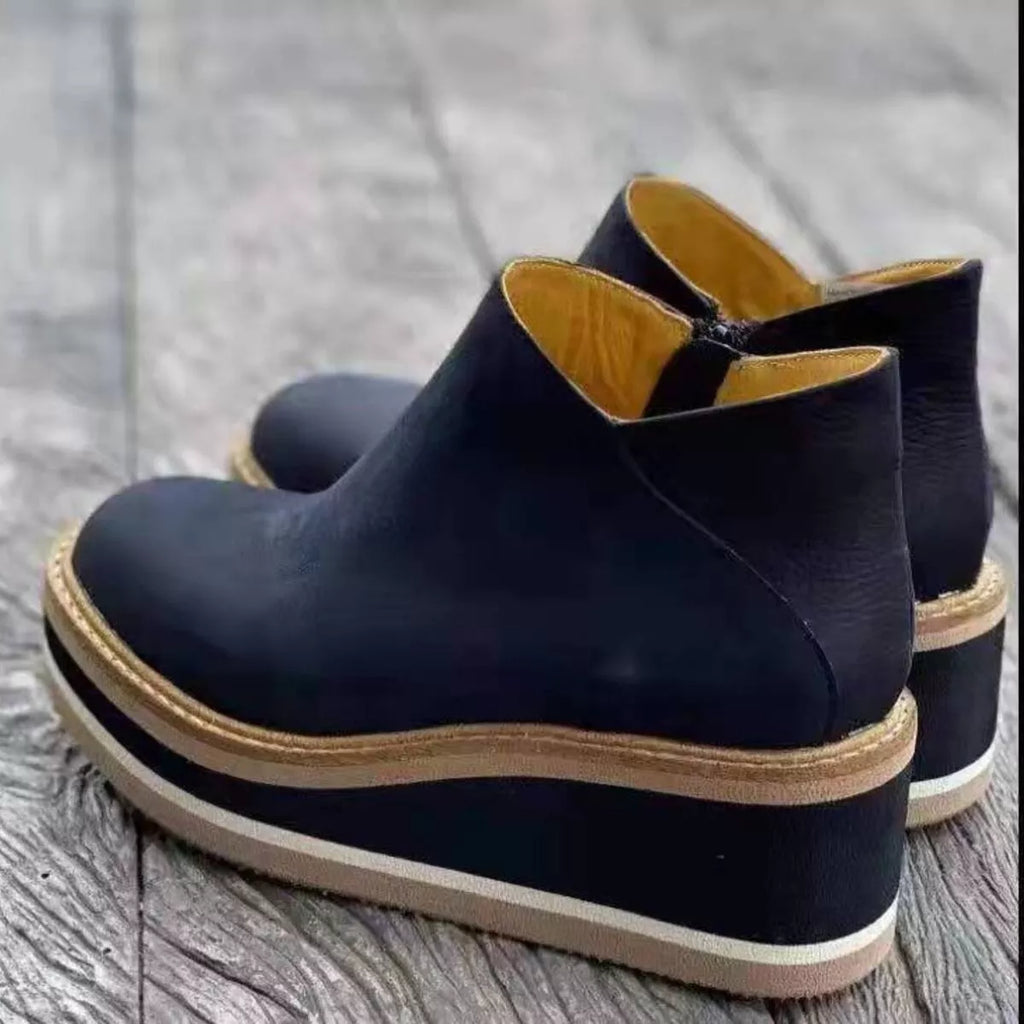 Dark navy ankle wedge boots with side zipper and tan striped outsole