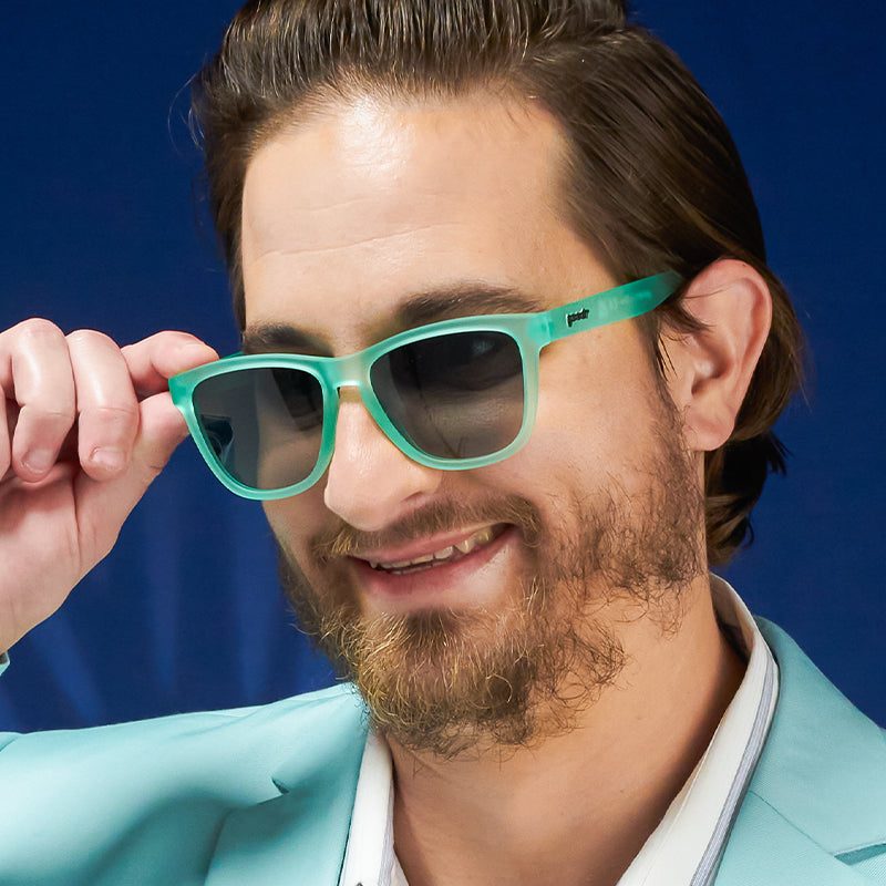 Mint teal sunglasses with dark polarized lenses, worn by man