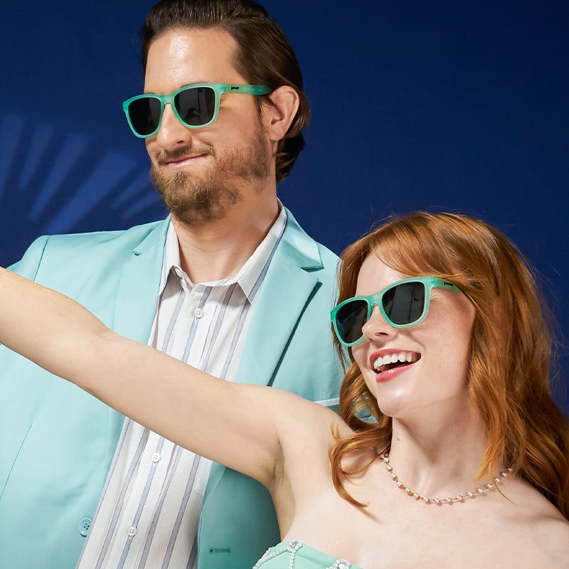 Mint teal polarized sunglasses with dark lenses, worn by couple