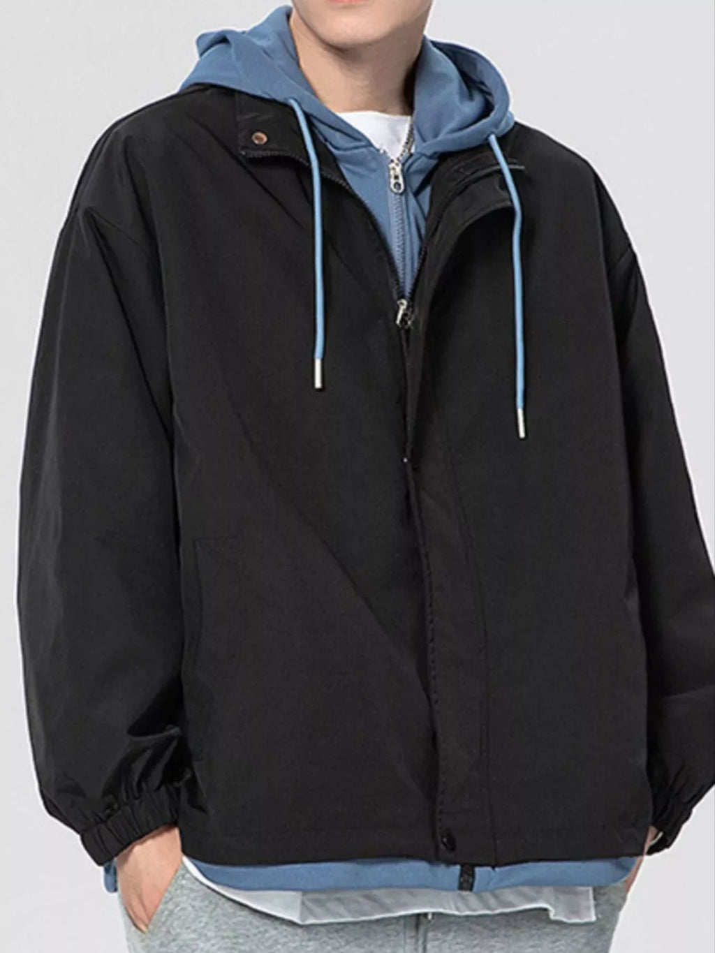 Black lightweight windbreaker jacket with attached hood, front zipper, and side pockets