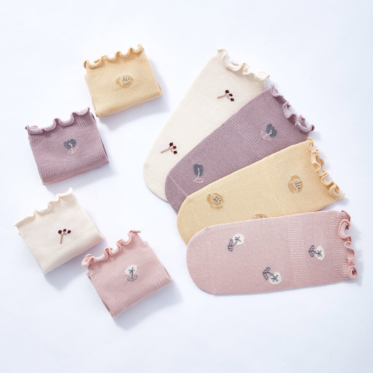 Set of 4 baby stay-on non-slip socks in pastel tones with ruffled cuffs and icons
