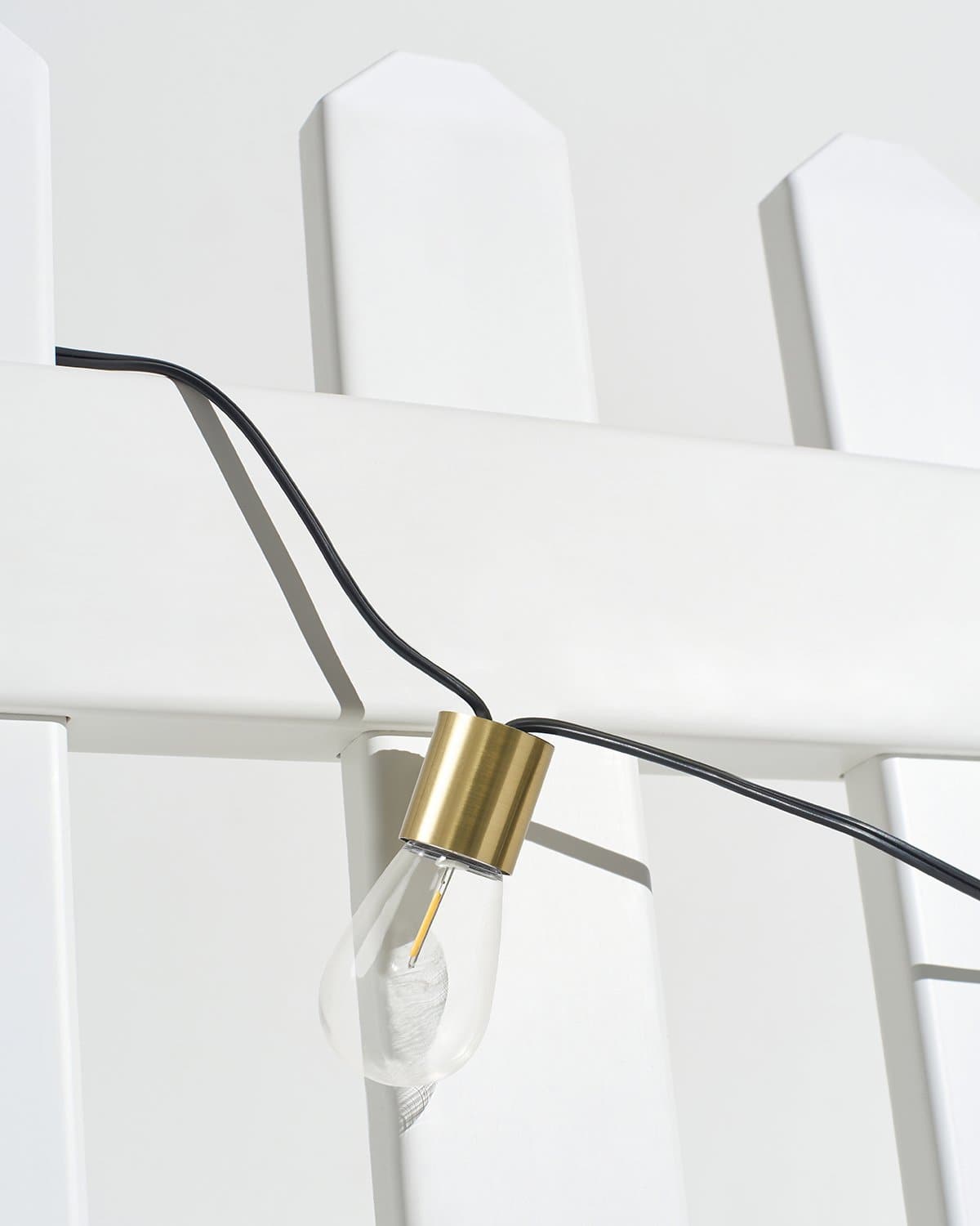 Solar string light bulb close-up with gold cap on black cord