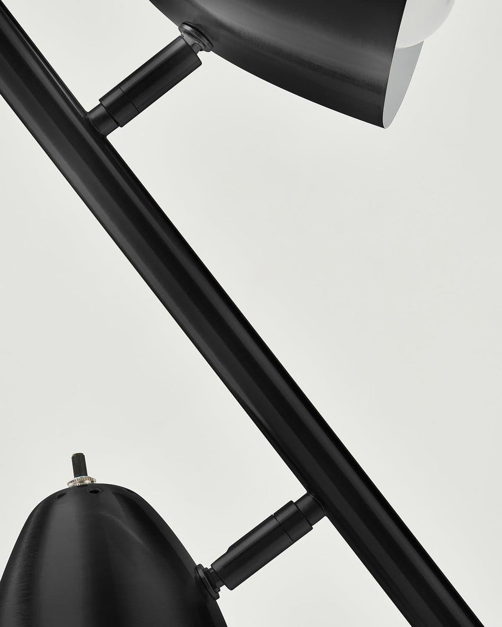 Black floor lamp detail: adjustable bar arms and cone shade mounts