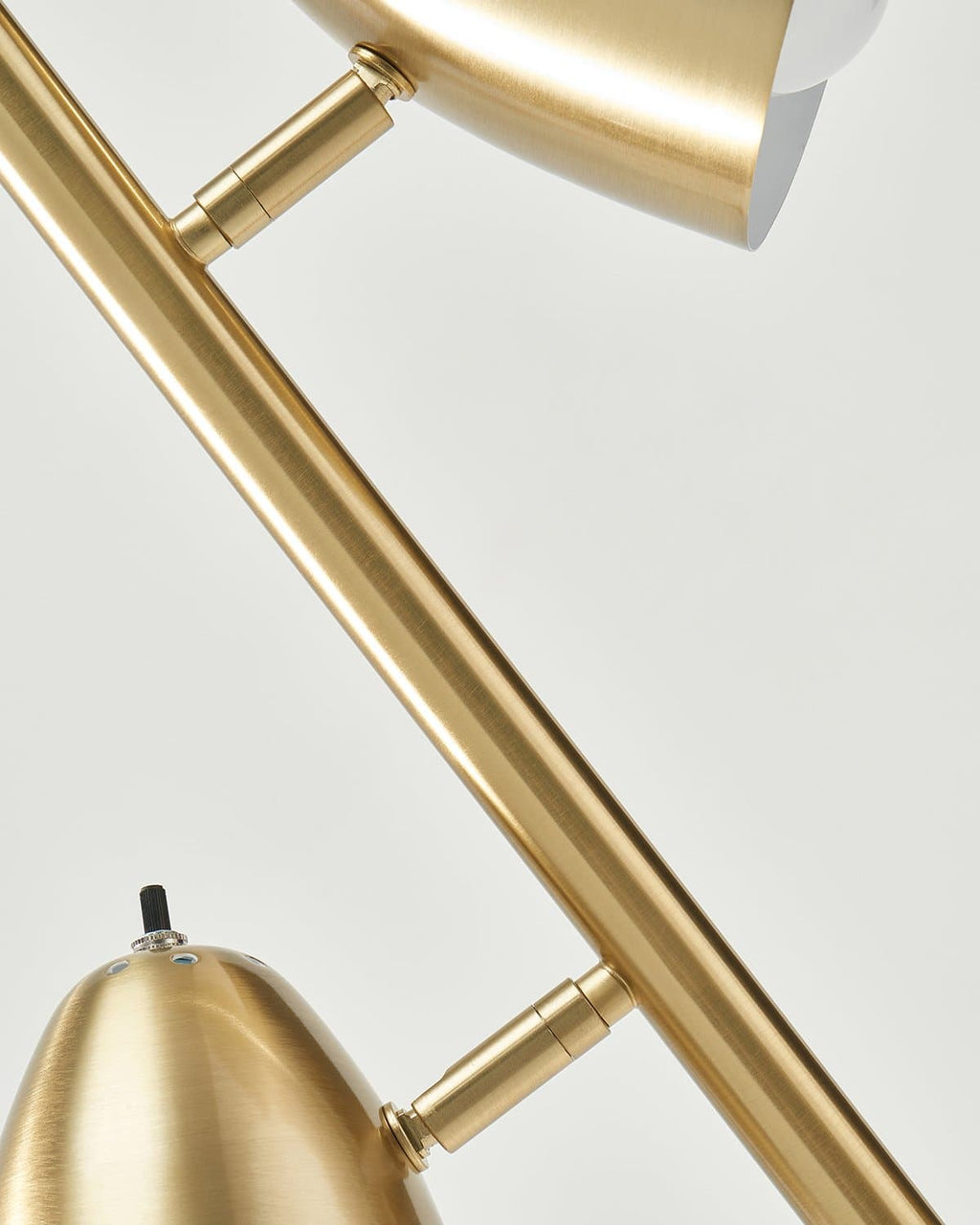 Brass floor lamp detail view of adjustable arms and cone shade mounts