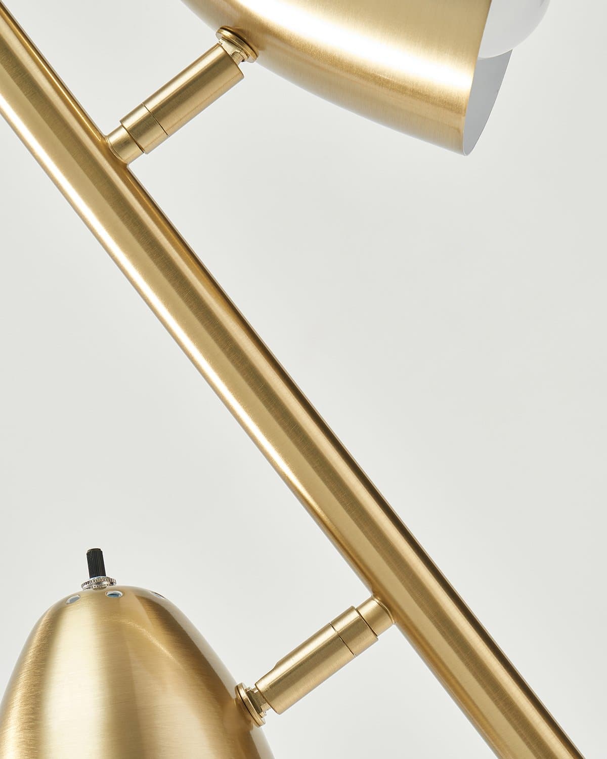 Brass floor lamp detail view of adjustable arms and cone shade mounts