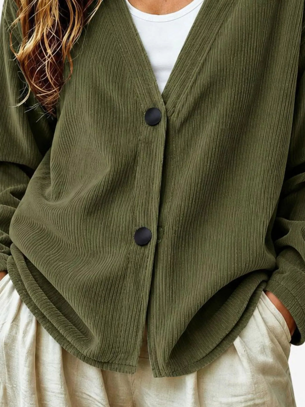 Olive green corduroy cardigan close-up, V-neck button front with two dark buttons