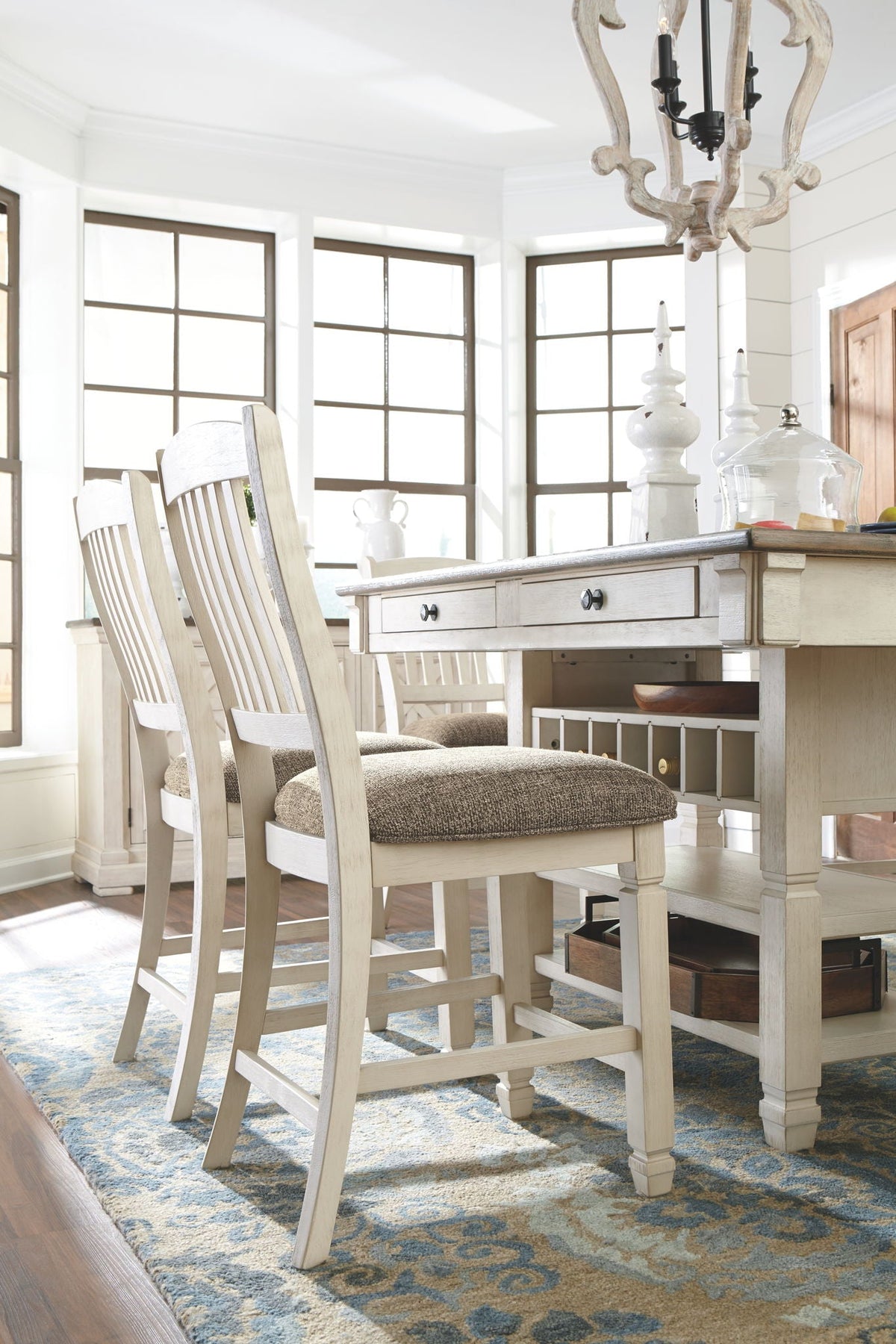 Single cream chair with gray cushion beside beige counter table and lower shelf storage.