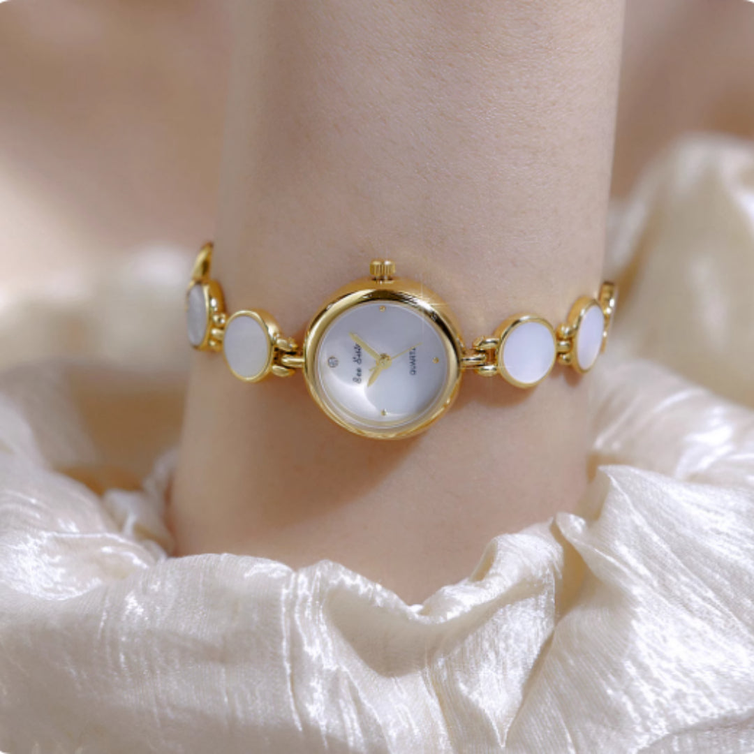 Gold watch bracelet with white mother-of-pearl bezel and oval link shells
